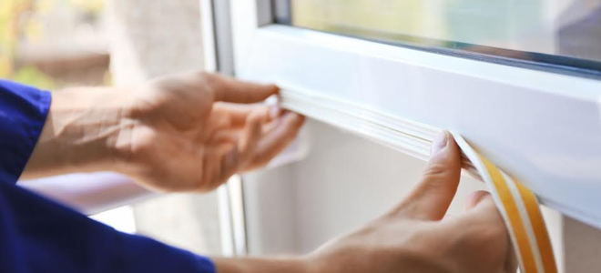 Applying weatherstripping to a window. 