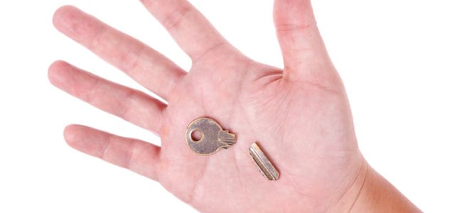A hand holding a broken key. 