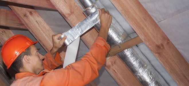 man taping ductwork insulation