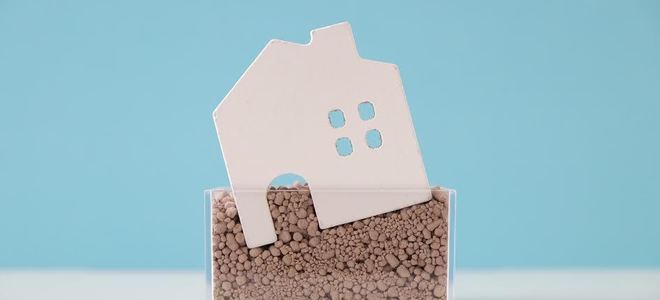 A small plastic house sinking into the ground.