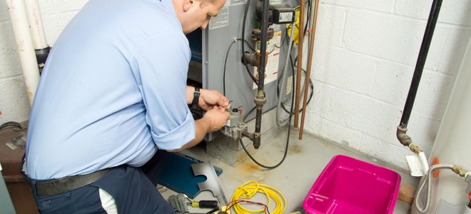 A man works on a furnace.