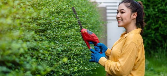 smiling woman with wireless power trimmers