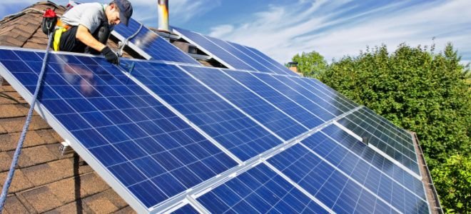 man on roof completing home solar power installation