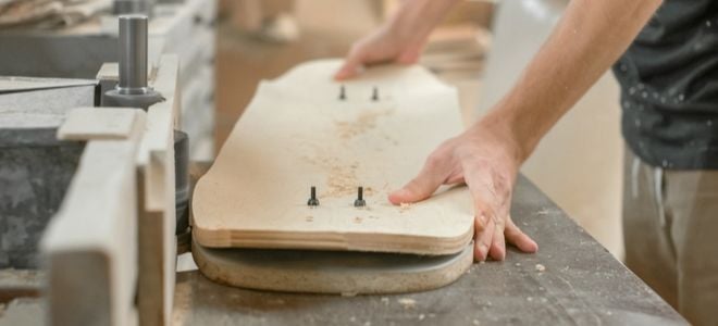 hand assembling a homemade wooden skateboard