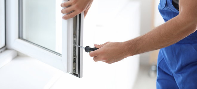 hands tightening window hardware with a screwdriver