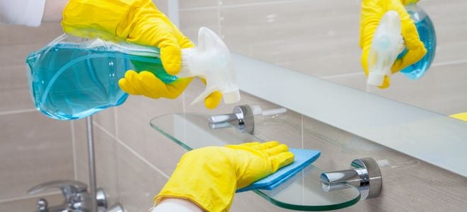 gloved hands cleaning bathroom