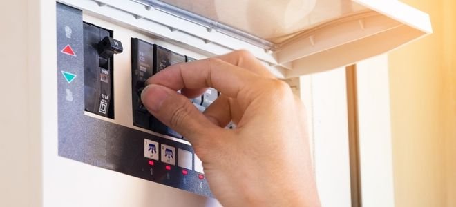 hand flipping power switch on circuit breaker