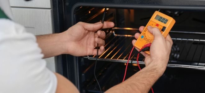 hands using multimeter to check oven voltage