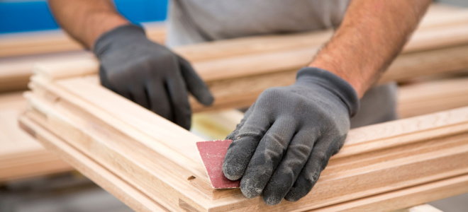 hands sanding wood frame