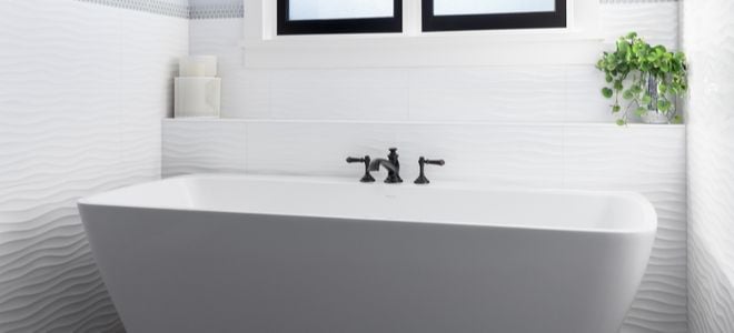 Black Roman faucet on white tub
