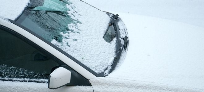 car under snow with windshield wipers