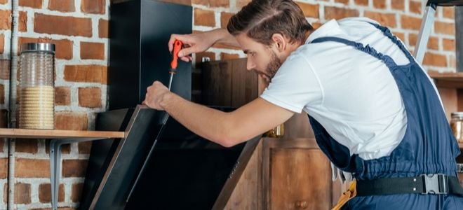 man disconnecting a range hood