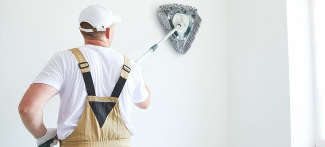 person preparing wall with cleaning stick