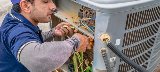 person working on an air conditioning unit