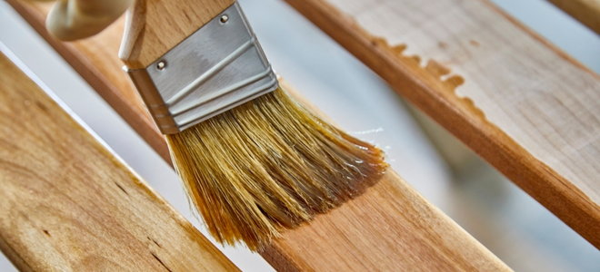 brushing varnish onto a wood surface
