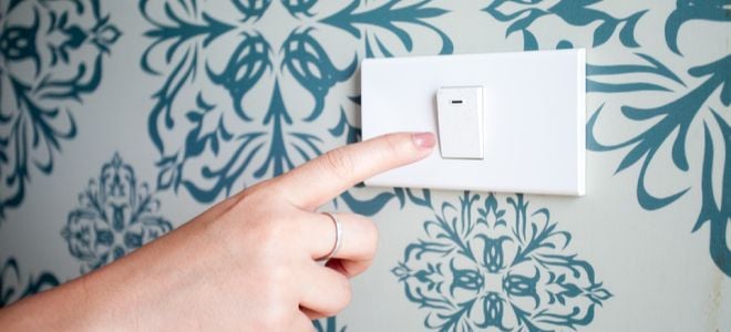 A switch plate against a wallpapered wall.