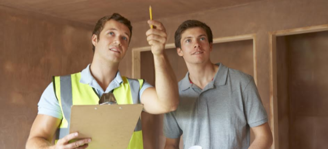 two men standing in a room discussing an inspection