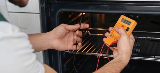 hands using multimeter in oven