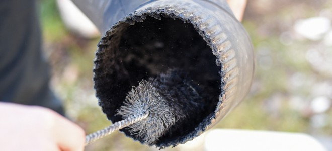 cleaning a stovepipe with a metal brush
