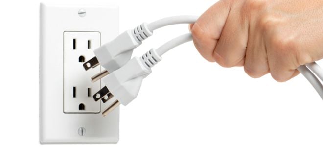 hand unplugging two appliance cords