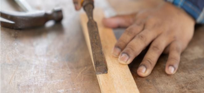 hands chiseling wood trim