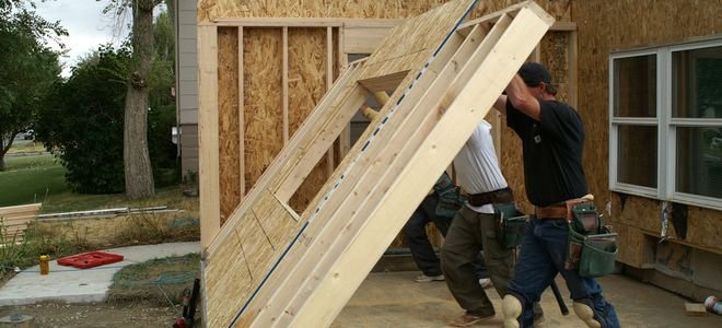 people installing wall for home addition