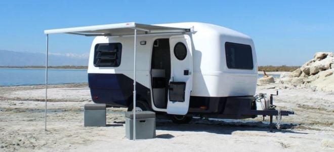 modern camper trailer on rocky beach