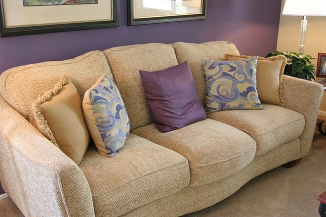 biege sofa against purple wall
