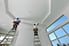 Two men on ladders installing molding around the edges of a tray ceiling.
