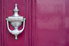 burgundy colored door with silver door knocker