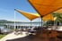 shade sails on a patio near water