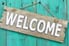 A decorative wooden sign that reads "welcome"