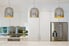 A trio of modern silver pendant lights hanging over a counter in a kitchen.