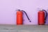 three fire extinguishers against a wall.