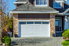 Home with white garage door and stone cladding accents