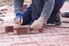 Person laying decorative bricks on a pathway