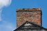 A brick chimney in front of a blue sky.