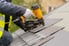 person shingling roof with nail gun