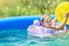 kid playing in inflatable pool with inflated toys