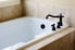 White bathtub with a black Roman tub faucet