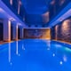 Indoor pool with side lighting on stone walls