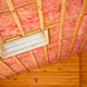 a framed ceiling filled with pink insulation
