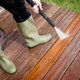 Using a power washer to clean a wood deck.