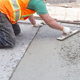 a person spreading concrete