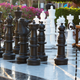 large scale chess set on patio near bench and bushes