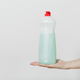 A hand holding a bottle of dish soap against a white background to be used for killing weeds.