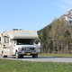 an RV on the road with mountains in the background