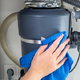 hand with rag cleaning garbage disposal