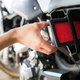 hand replacing air filter on motorcycle