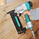 A nail gun being used to nail wood boards to supports.